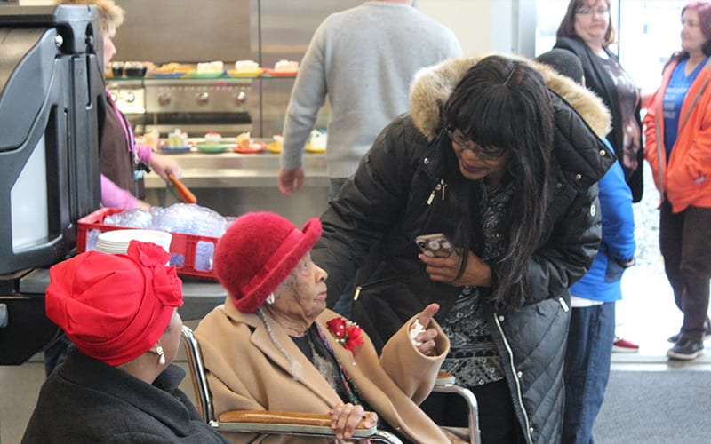 volunteers helping elderly woman at TCUGM