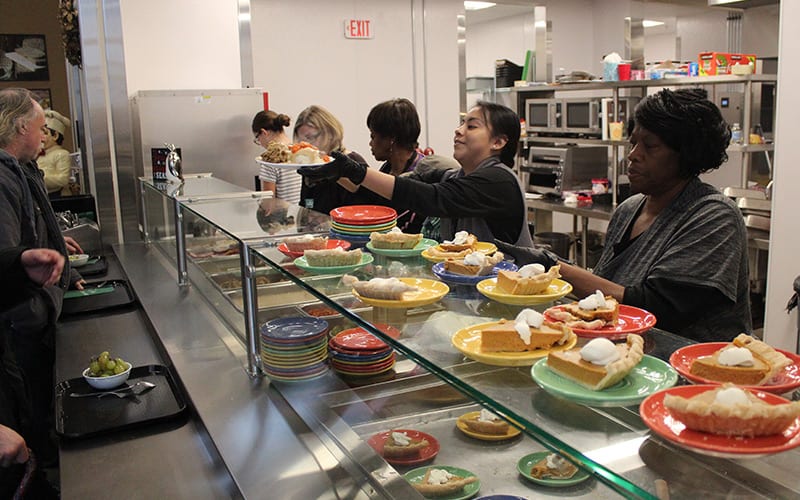 volunteers serving Thanksgiving dinner at TCUGM